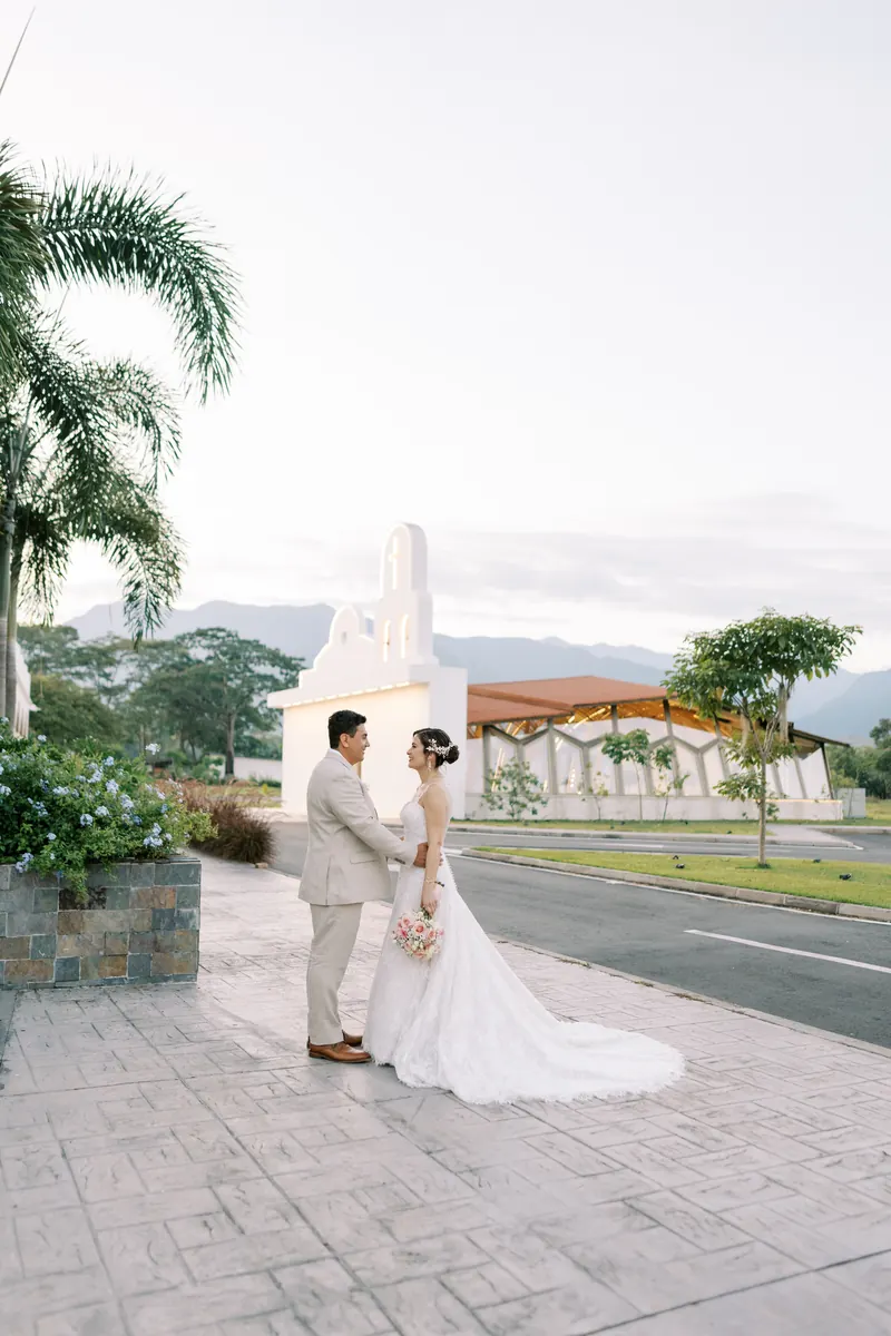 Novios de día frente a la capilla de Hacienda Las Marías con las montañas del Meta al fondo